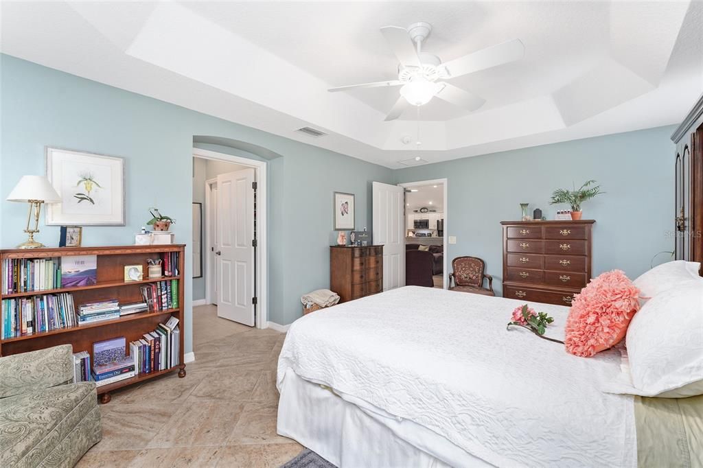 View from back corner of PRIMARY BEDROOM - Shows diagonal set TILE FLOORING, octagonal TRAY CEILING, entrance to ENSUITE BATHROOM (L center), and entrance to PRIMARY BR (back center).