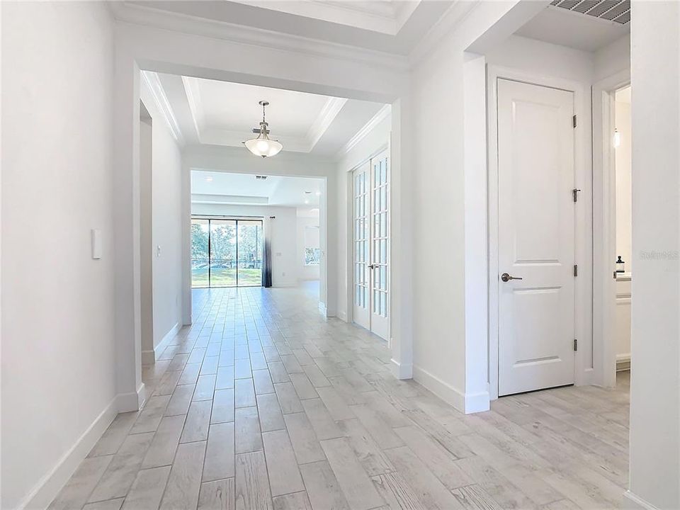 View from front door into home featuring Double Tray Ceiling and Coat Closet.