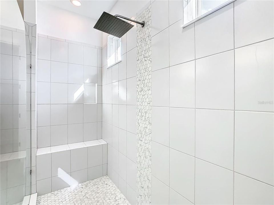 Walk-in Shower with upgraded tile, built in seat, rain shower, 2 built in shampoo holders, and is 10' long with daylight windows.