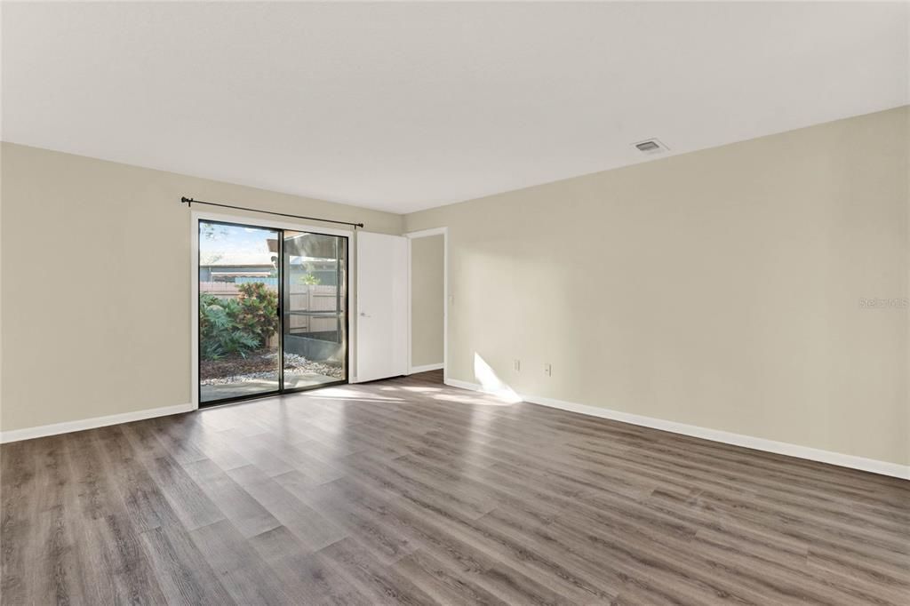 Primary bedroom has sliding glass doors leading to backyard