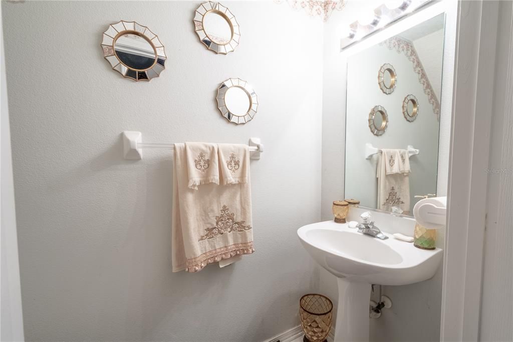 1st floor half bath off of the living room with pedestal sink and commode.