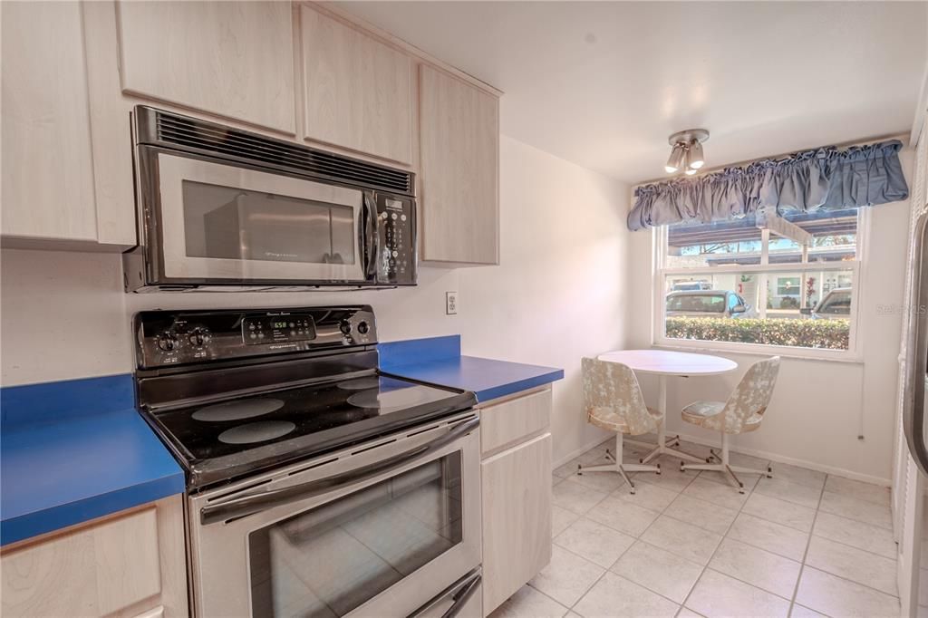 The kitchen features a suite of stainless steel appliances including a range, microwave, French door refrigerator with ice maker and water dispenser, and a dishwasher.