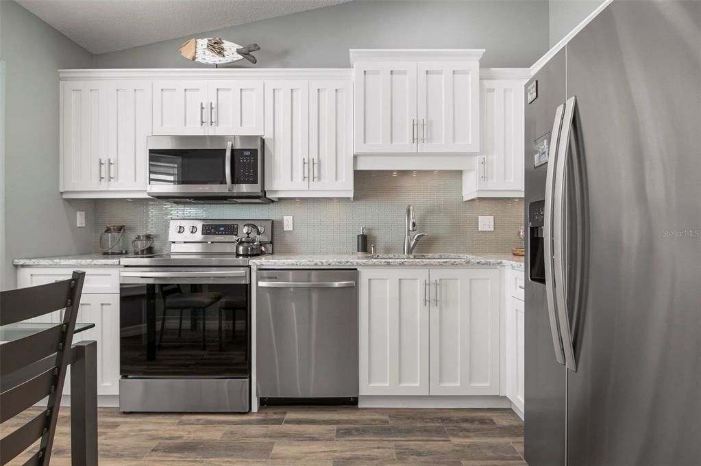 Kitchen with stainless appliances and shaker style cabinetry