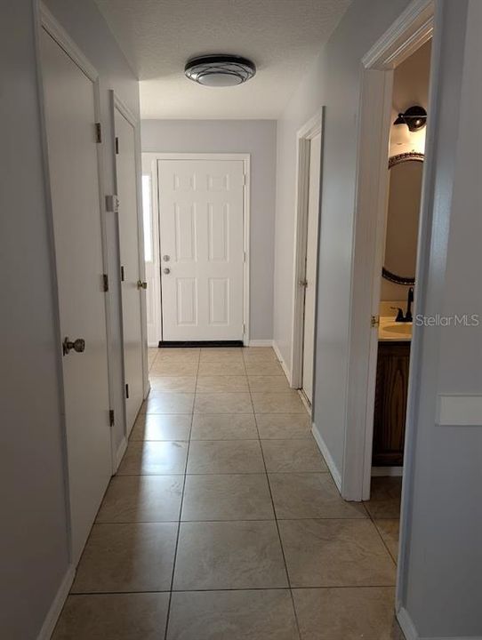 View from family room of entry, half bath, closets and door to garage