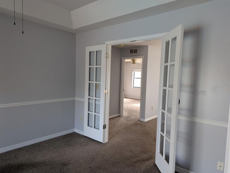 Den with french doors leading to living room and primary bedroom