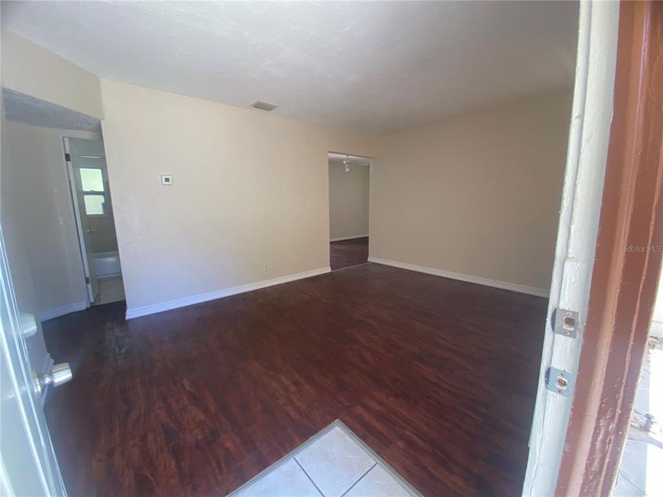 Looking into Living Room from front door. Opening to left leads to 2 bedrooms & the bath. Opening to the right leads to kitchen/dining area & 3rd bedroom.