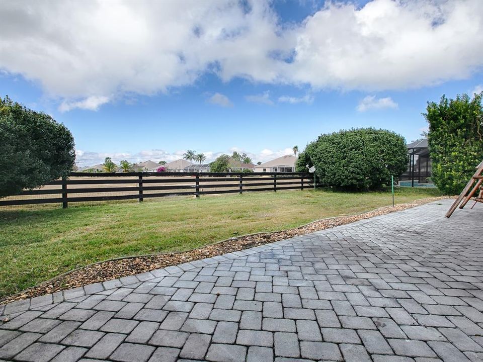 PAVER PATIO WITH WILDLIFE PRESERVE JUST BEYOND THE FENCE