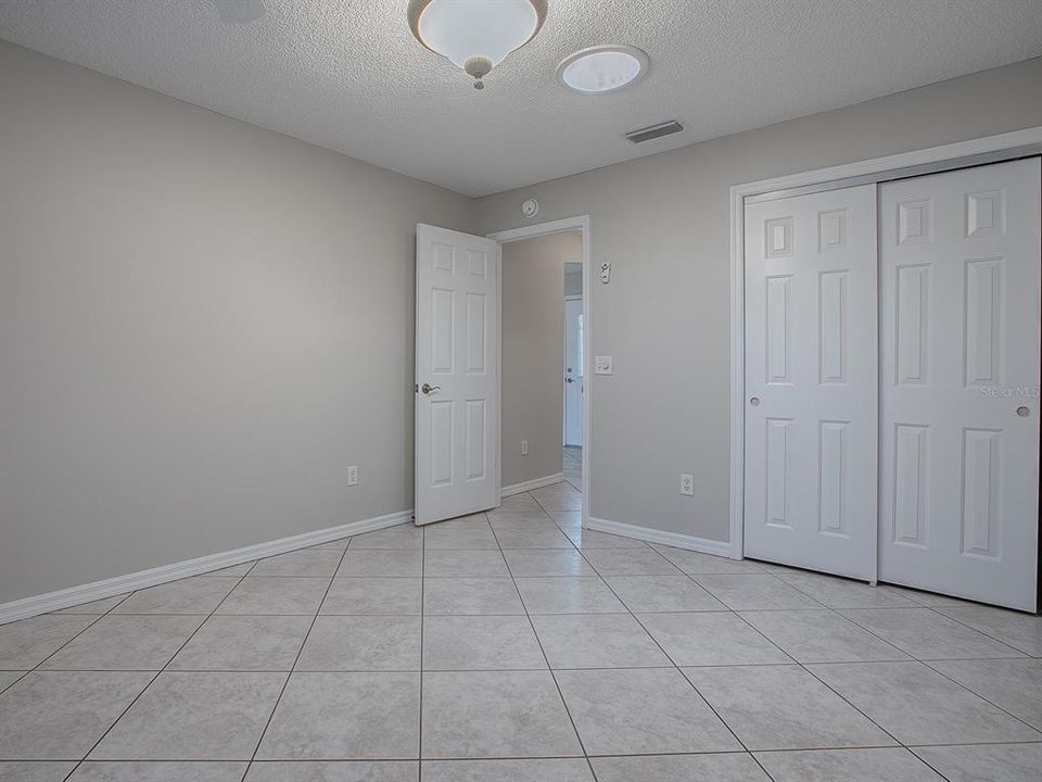 REAR GUEST BEDROOM WITH CLOSET & CERAMIC TILE FLOORING