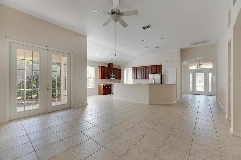 Standing in family room looking towards the kitchen.  Double French doors on the left lead to lanai.   Top right is the front door.  Behind the kitchen is a built in desk/ work station.  Laundry room, and formal dining room.  To the right of the front door is the living room, half bath/ guest bathroom. and forth bedroom.