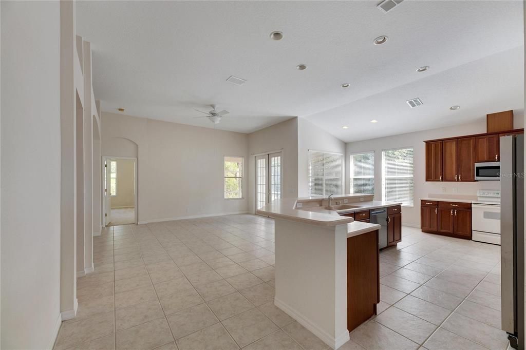 Large eat in Kitchen and family room combination.  In the back center of the picture are double French doors leading to the lanai.