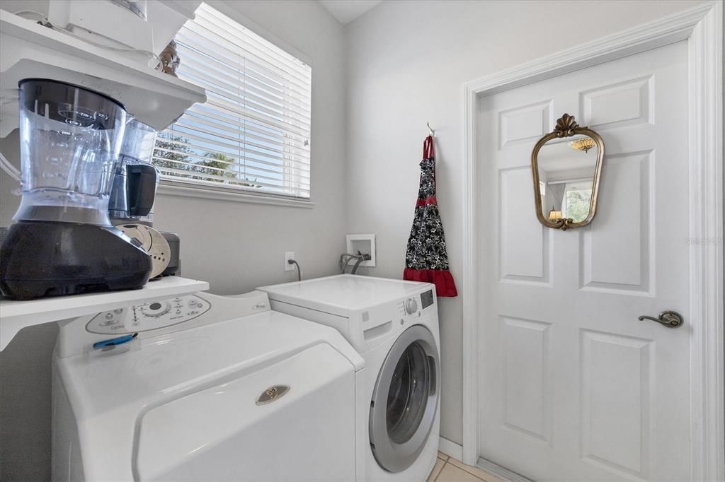 Inside laundry room with full size washer and dryer and a window.