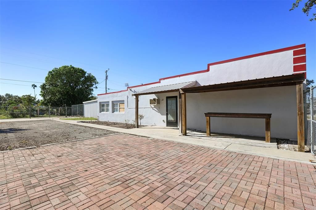 Side view of building with rear alley access and the metal building