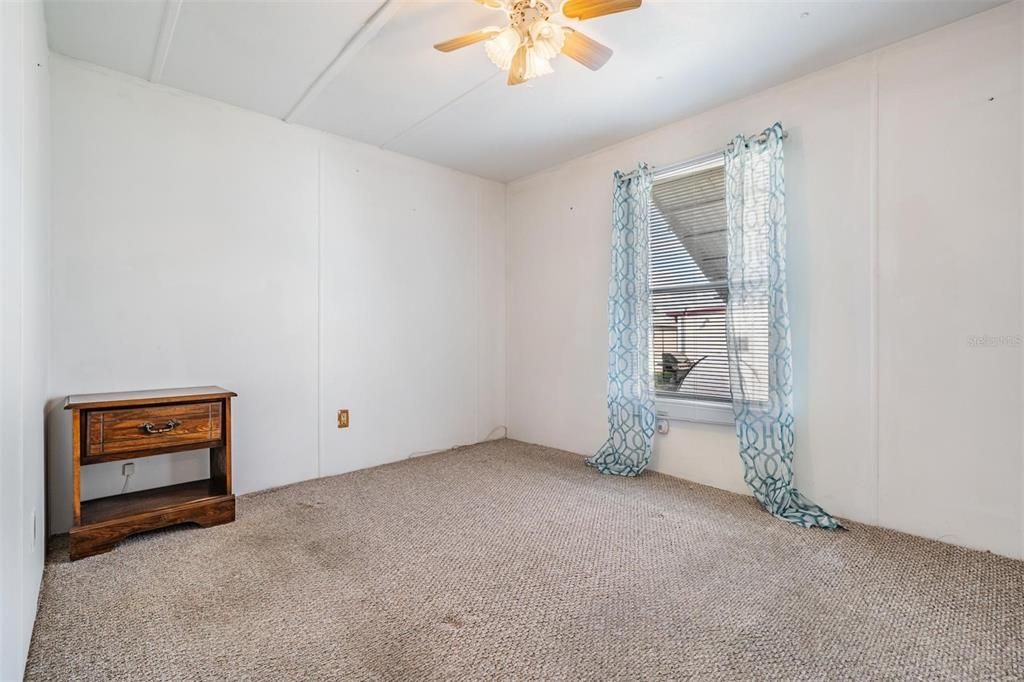 Primary bedroom at back of home with Berber carpet