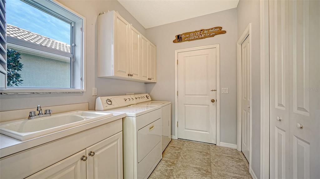 Laundry room with sink and two large storage closets is conveniently located off of the kitchen