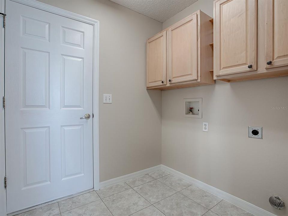 THE LAUNDRY ROOM HAS CABINETS FOR EVEN MORE STORAGE SPACE