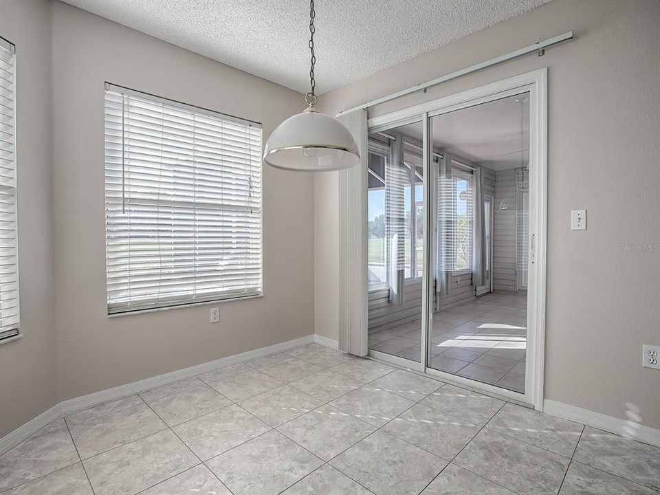 PLENTY OF NATURAL LIGHT IN THIS CASUAL DINING SPACE... GLASS SLIDERS LEAD TO THE ENCLOSED FLORIDA ROOM