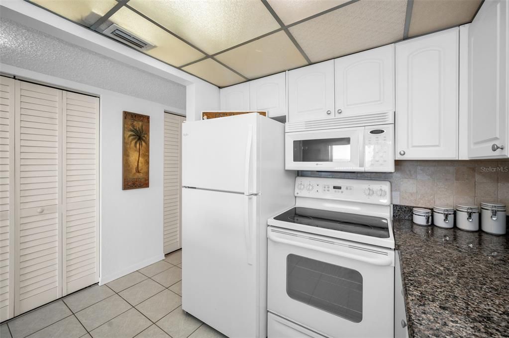 Light & Bright Kitchen with Granite Surfaces, Breakfast Bar and White Appliances.