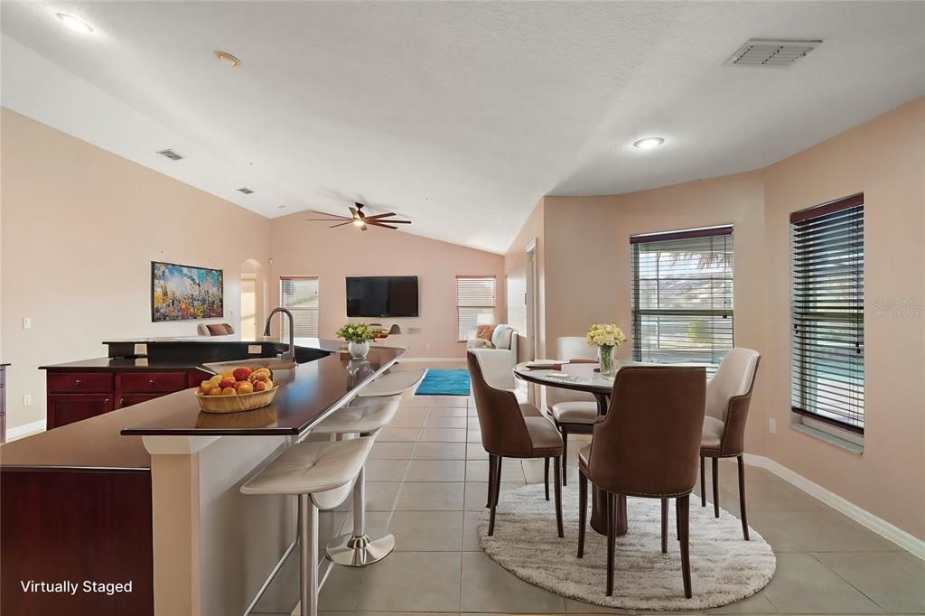 View of kitchen, breakfast nook, and family room (virtually staged)