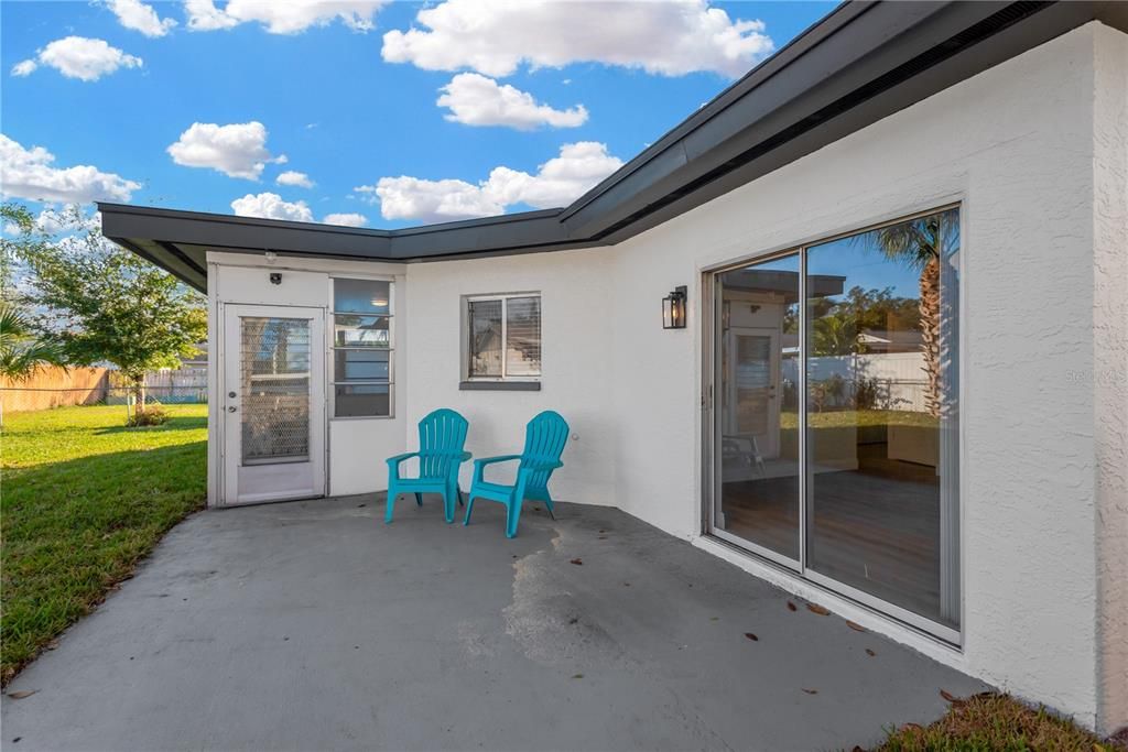 Back Patio with Guest Bedroom Slider, Kitchen window and door to the Florida Room