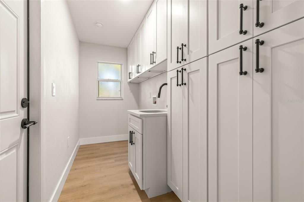 Laundry room w/ utility sink and cabinets storage