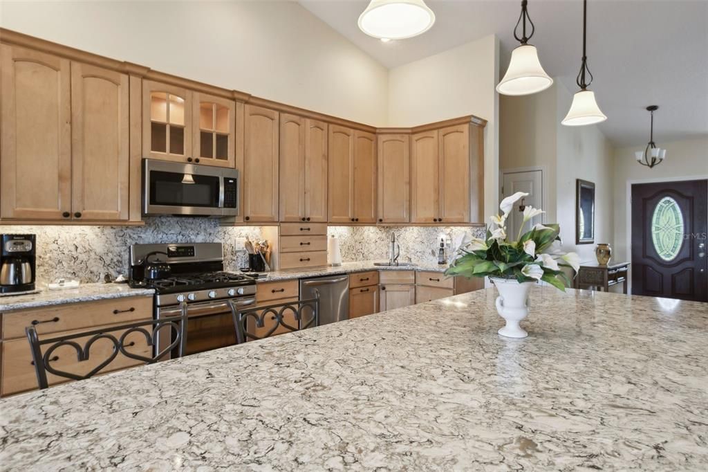 High wooden cabinets, Large island counter is quartz to prepare or share meals