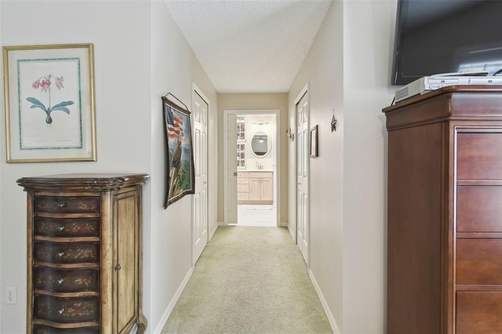 Hallway in primary to his & her closets & primary bathroom