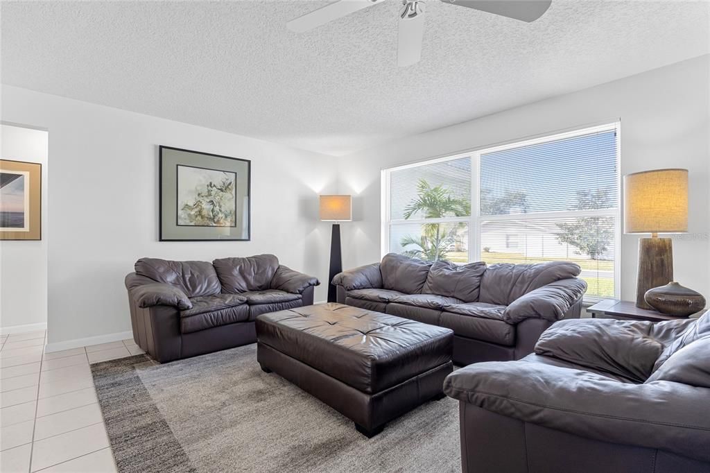 The Formal Living room has large windows that give a perfect view of the front yard and nightly sunsets!