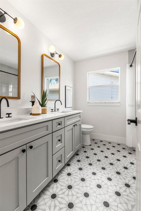 Guest bathroom with mosaic tile flooring and double sink quartz vanity