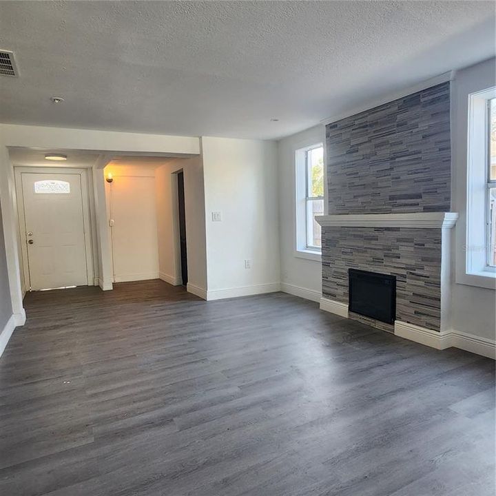 Family looking toward entrance. There is a nook by the door which could be used for a drop zone, bookcase, or whatever you want.