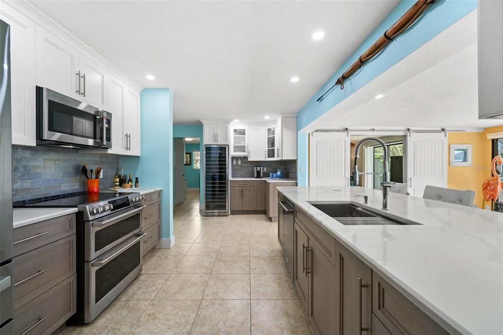 Updated Kitchen with Quartz Countertops and Farmhouse-Style Sink, Stainless Steel Appliances.