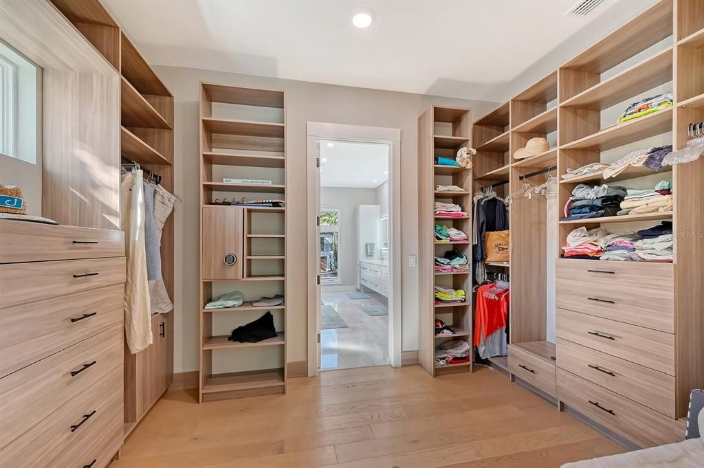 Walk-in closet has plenty of storage space, built ins, and a safe.