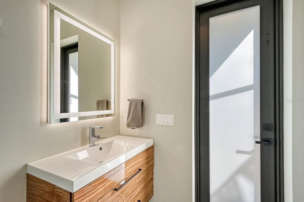 Another view of full bath in guest suite leading to backyard area.