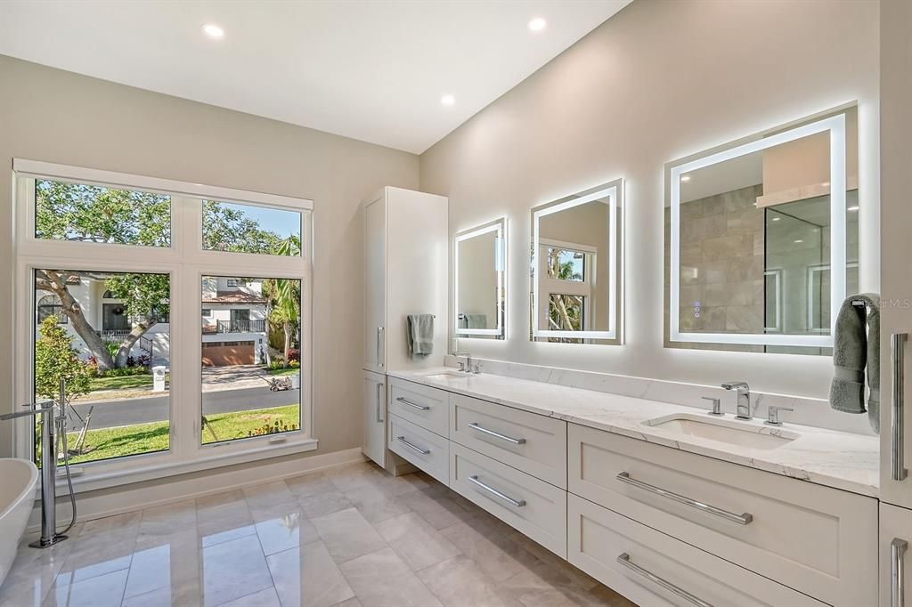 Spa inspired full primary bathroom has heated floors and double sinks.