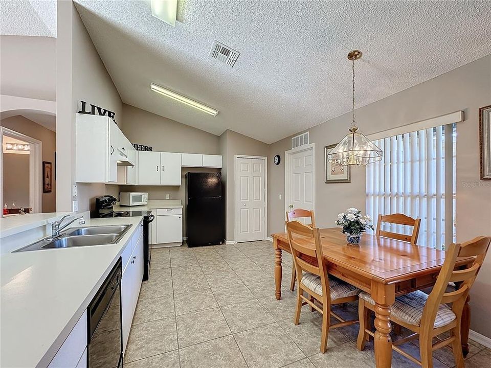 The kitchen and the living room have tile flooring and vaulted ceilings.