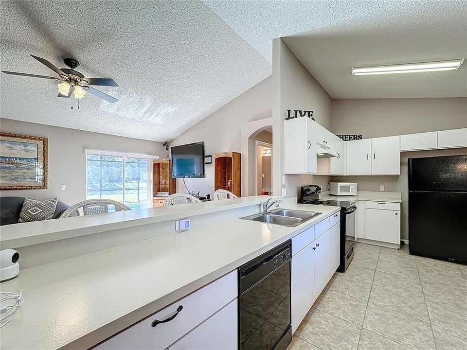 The kitchen has a breakfast bar.  While preparing a meal, you'll be able to look into the living room and out to the pool and pond out back.