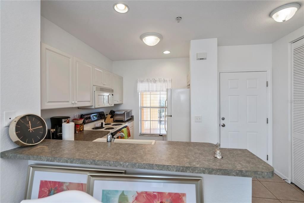 Front door entry and gleaming, breakfast bar kitchen.