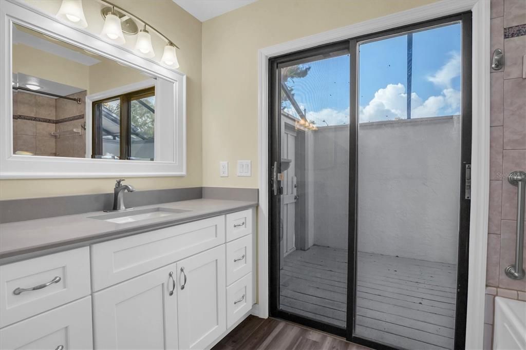 Ensuite Master (Primary)Bathroom. Glass doors lead to atrium/lanai