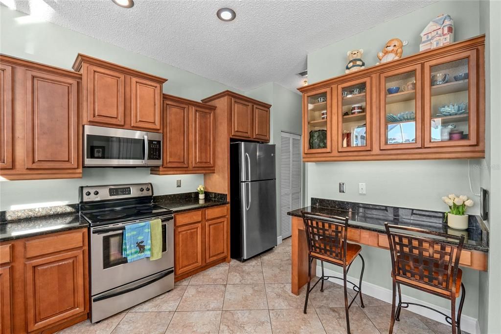 Wood Cabinets and stainless steel appliances in this large Kitchen