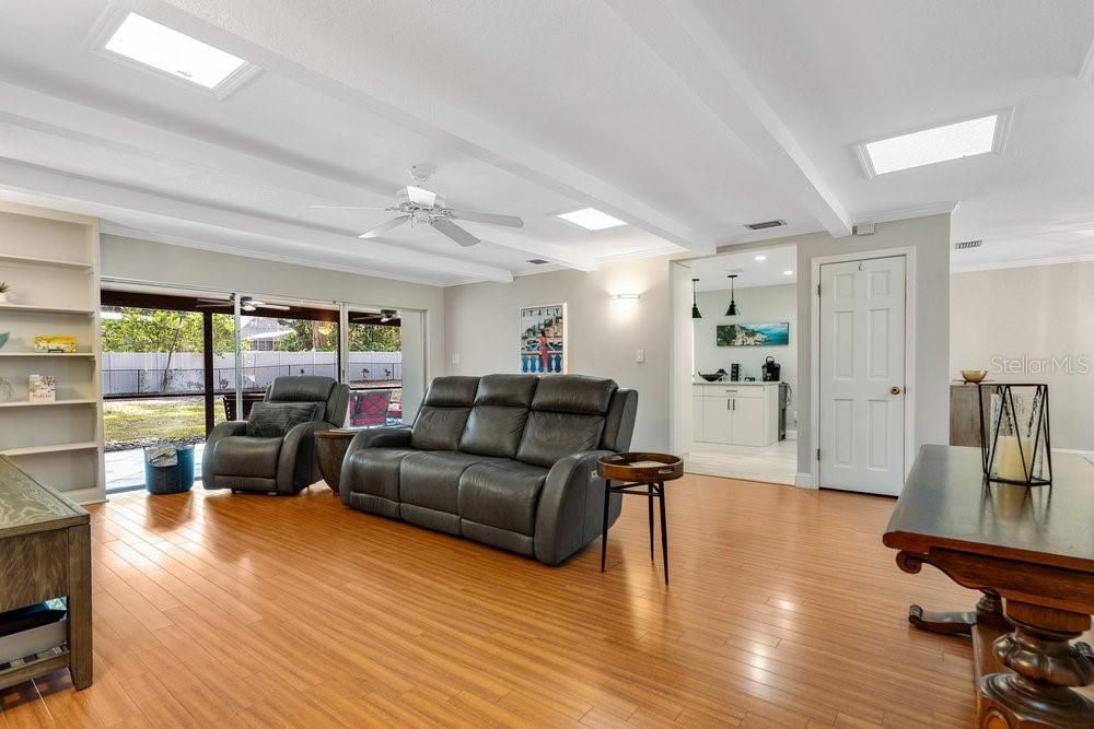 Living Room with skylights and view of Kitchen and backyard