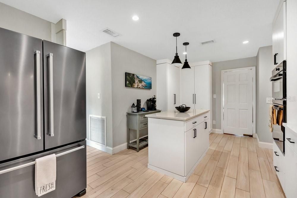 Beautifully updated Kitchen with smudge-proof refrigerator, cabinets for pantry/storage, and swinging door to Dining Room