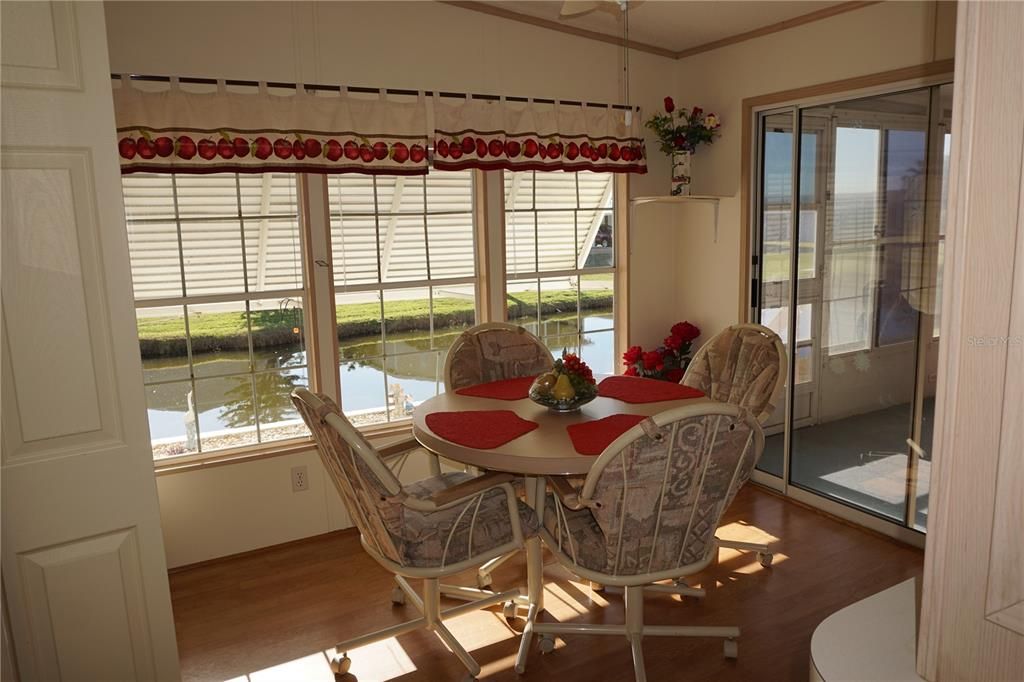 Breakfast nook overlooking pond and sliding glass doors open to enclosed lanai