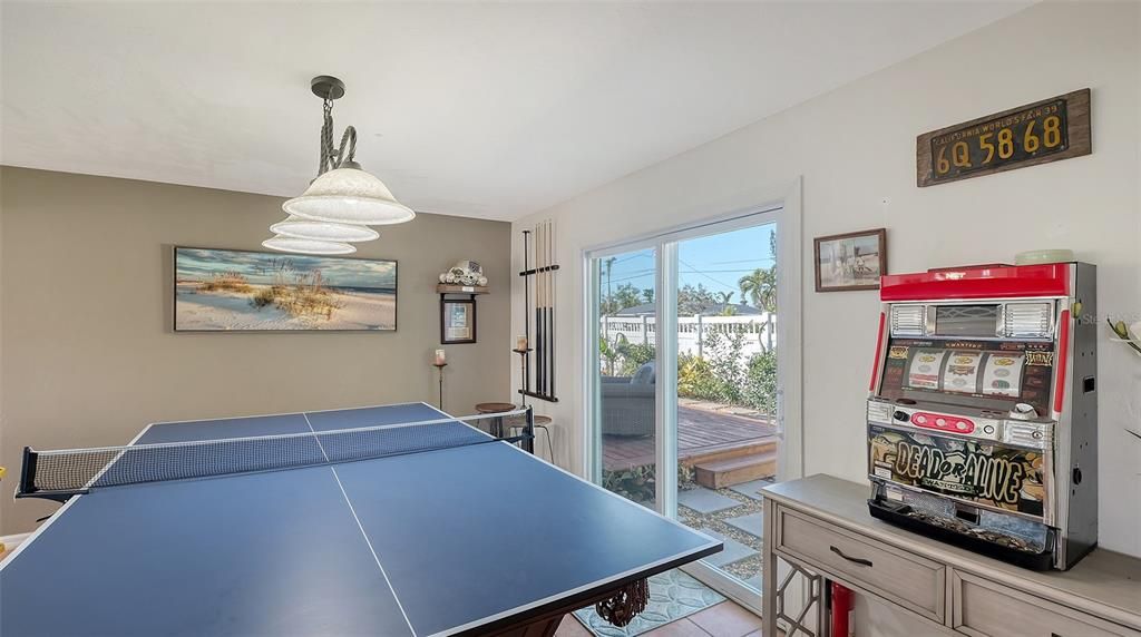 Dining room transformed to a game room with pool and ping pong table.