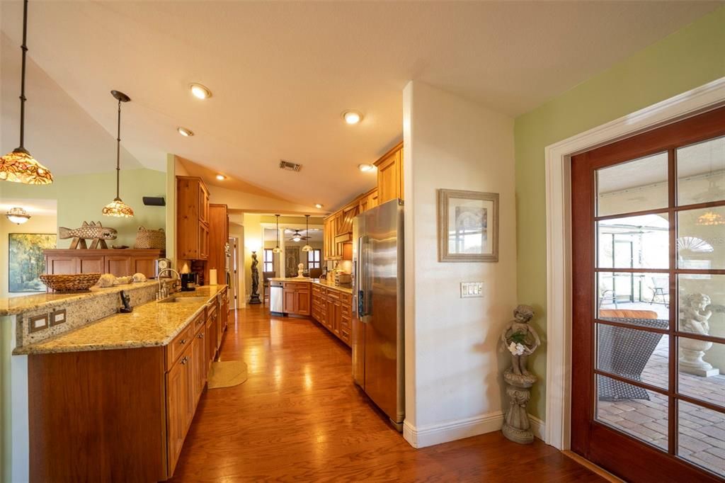 Kitchen with granite counters and stainless appliances. French doors lead to the lanai