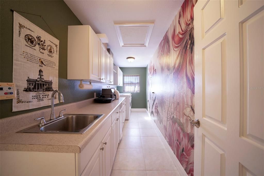 Inside laundry with sink and lots of storage.