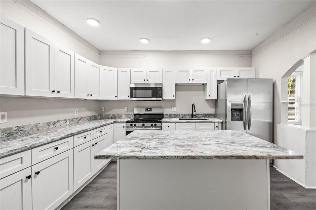 Kitchen with white shaker cabinets, new appliances, Center Island, and stainless steel sink