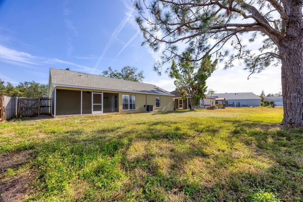 Large back yard with partial fence and gate