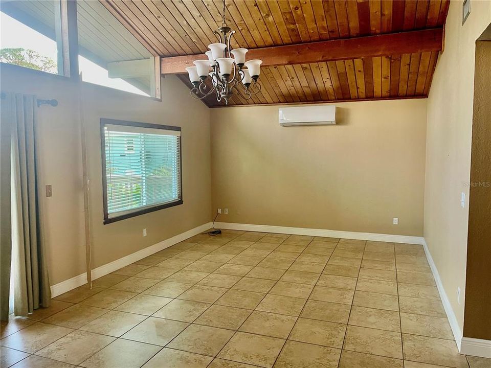 Looking from dining area into living room area. Doors on left lead to open deck and stairs down to pool area.