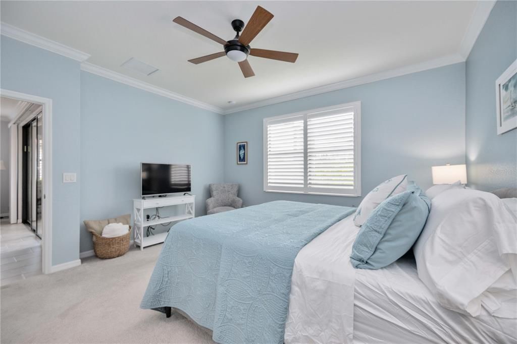 Master bedroom with crown molding and plantation shutters