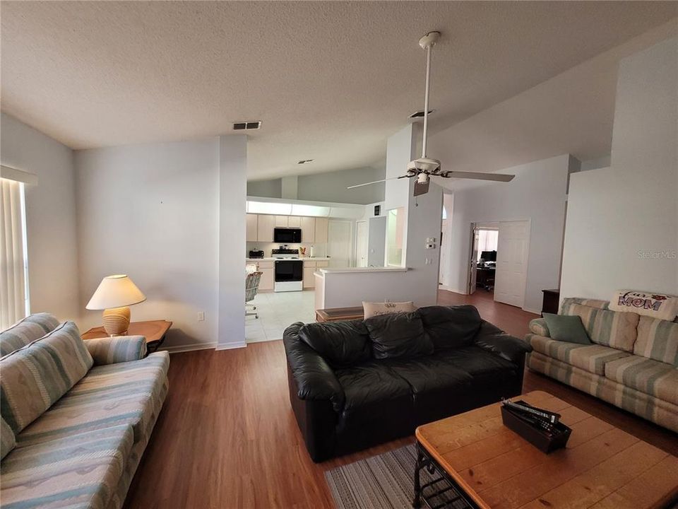 Large living area with vaulted ceiling opens to kitchen