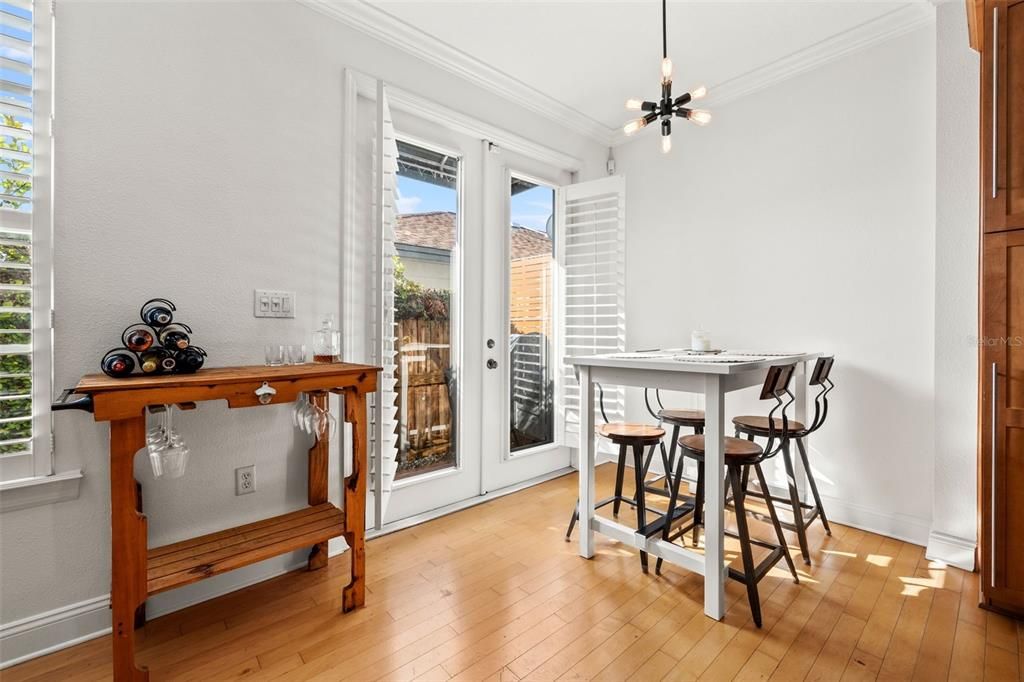 French doors off dining lead to the private pavered side yard and garden